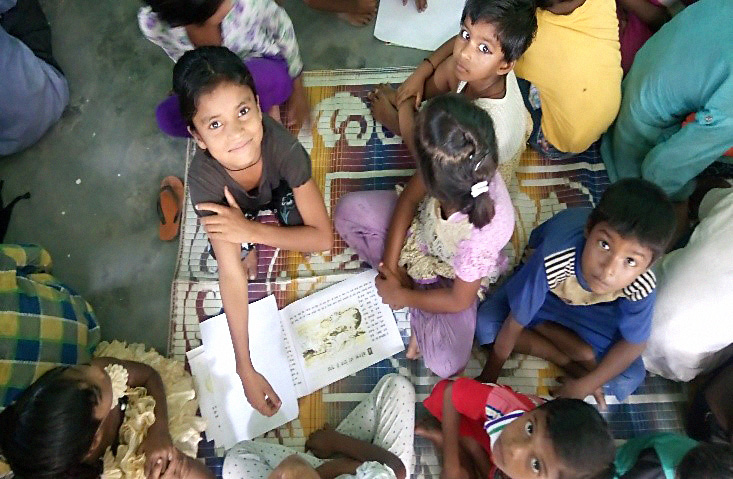 “Children reading books during Mobile Library’s visit in Jajal Tokki Village ” by Dr Rangashri Kishore is licensed under CC BY 4.0